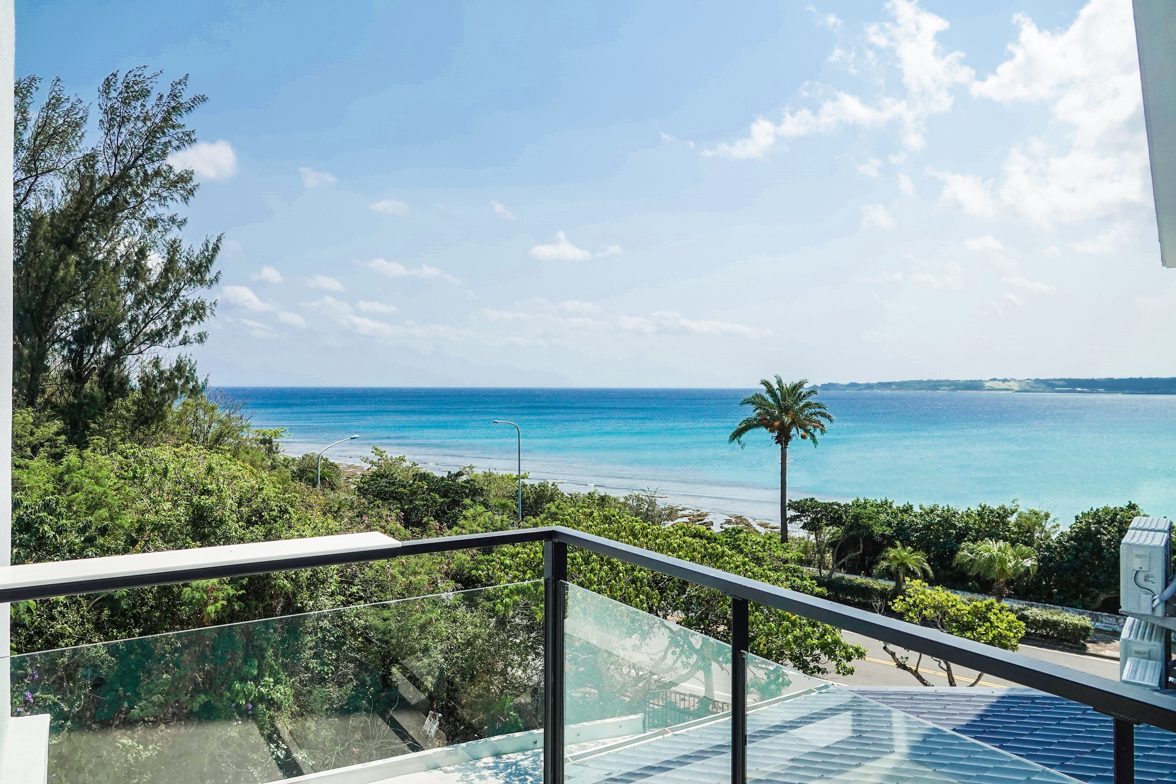 A balcony with a clear view of the ocean and beach.