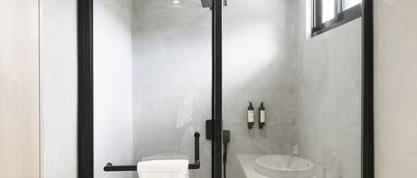Une salle de bain moderne avec une douche à parois de verre, un lavabo blanc et un porte-serviettes.