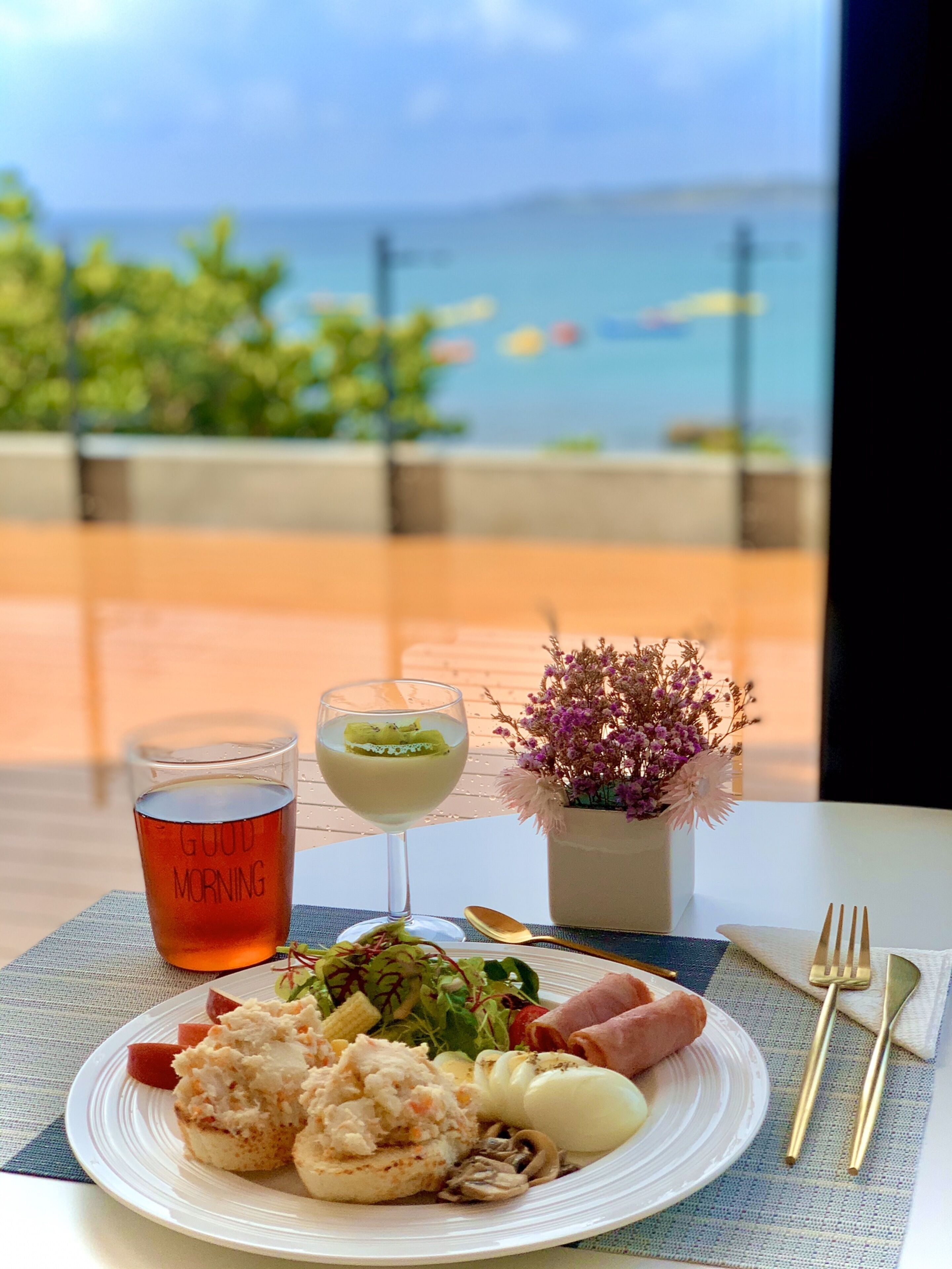 Ein Tisch mit Mahlzeit, einer Teetasse und Blick auf das Meer.