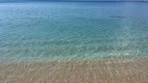 On peut clairement voir une plage avec une eau peu profonde et un rivage sablonneux.