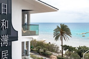 A modern building with a balcony overlooking a beach with boats. - Sunshine Liv. (Hengchun)