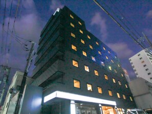 A multi-story hotel with illuminated windows and a prominent entrance. - Hotel Livemax Okayama West (Okayama)
