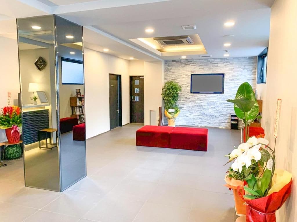 A modern interior with a red sofa, a flat-screen TV, and a stone wall.