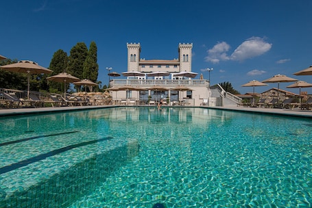 Una piscina al aire libre de temporada, sombrillas