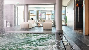 A hotel lobby with a water feature, seating area, and a view of the outdoors. - Castello Bonaria Wine & Spa Resort (Campiglia Marittima)