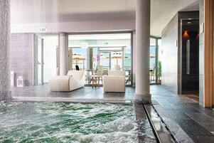 A hotel lobby with a water feature, seating area, and a view of the outdoors.