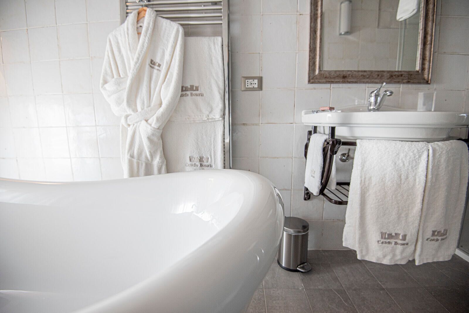 A modern bathroom with a large bathtub, a sink, and a mirror.