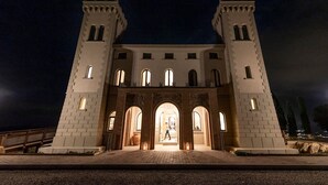 A castle-like building with two towers and a central entrance with arches. - Castello Bonaria Wine & Spa Resort (Campiglia Marittima)