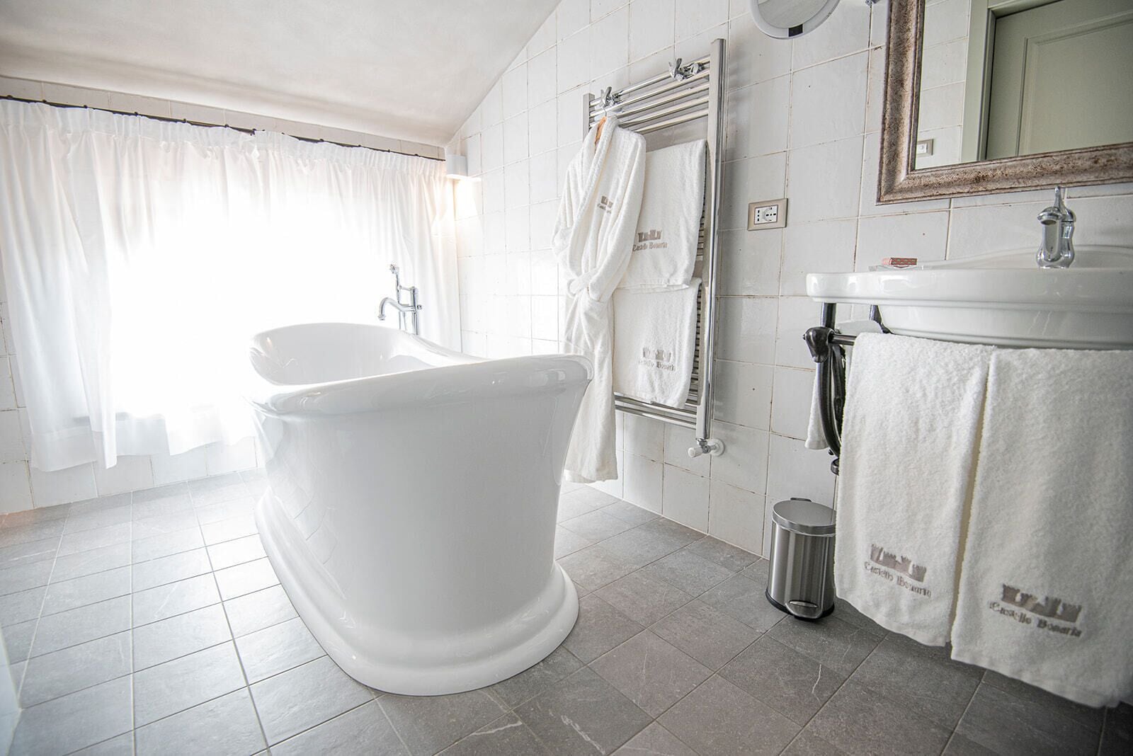 A modern bathroom with a freestanding bathtub, a sink, and a mirror.