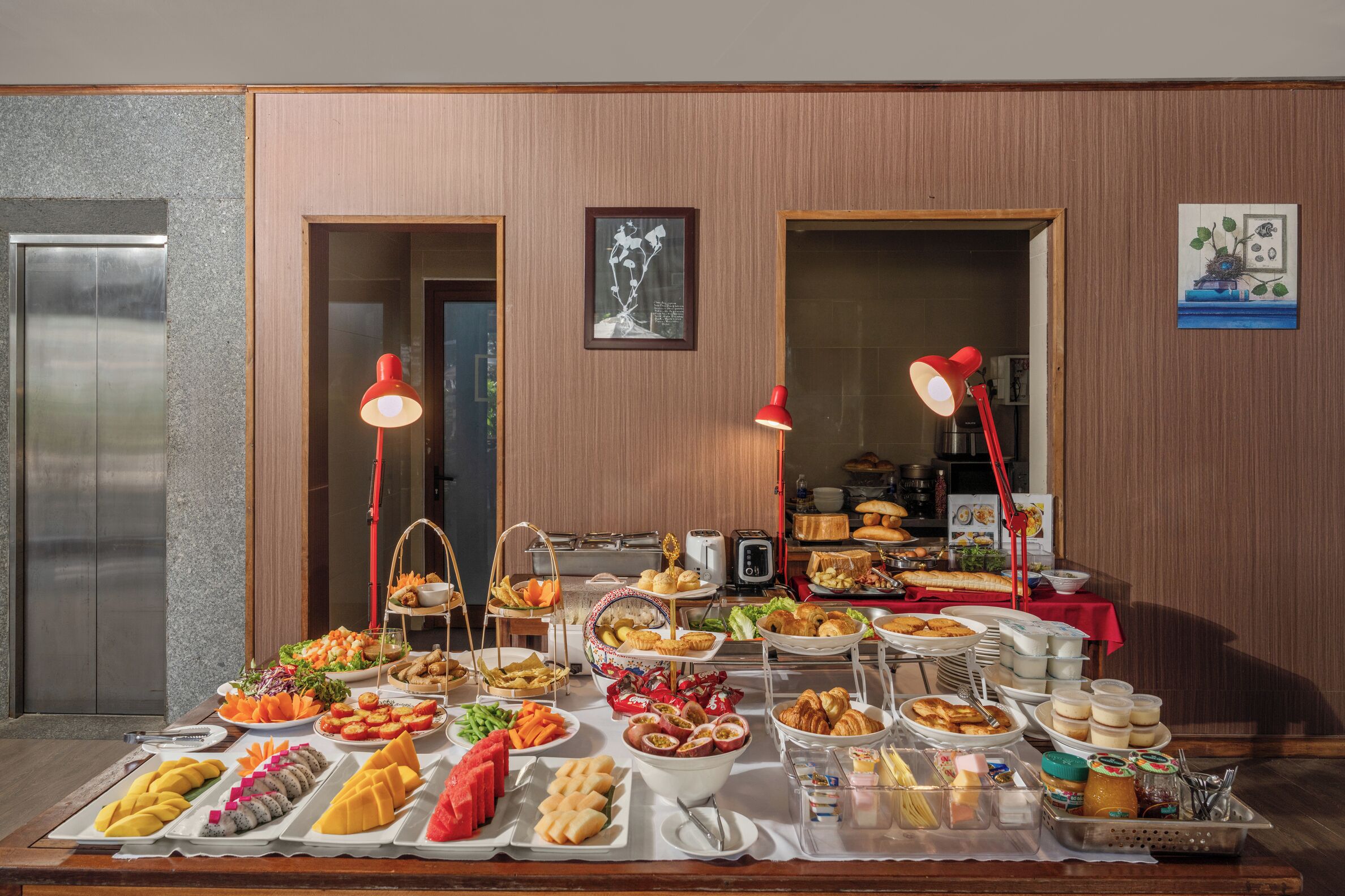 A buffet table with various food items and a red lamp.