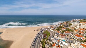 Uma cidade costeira com praia, estradas e edifícios.