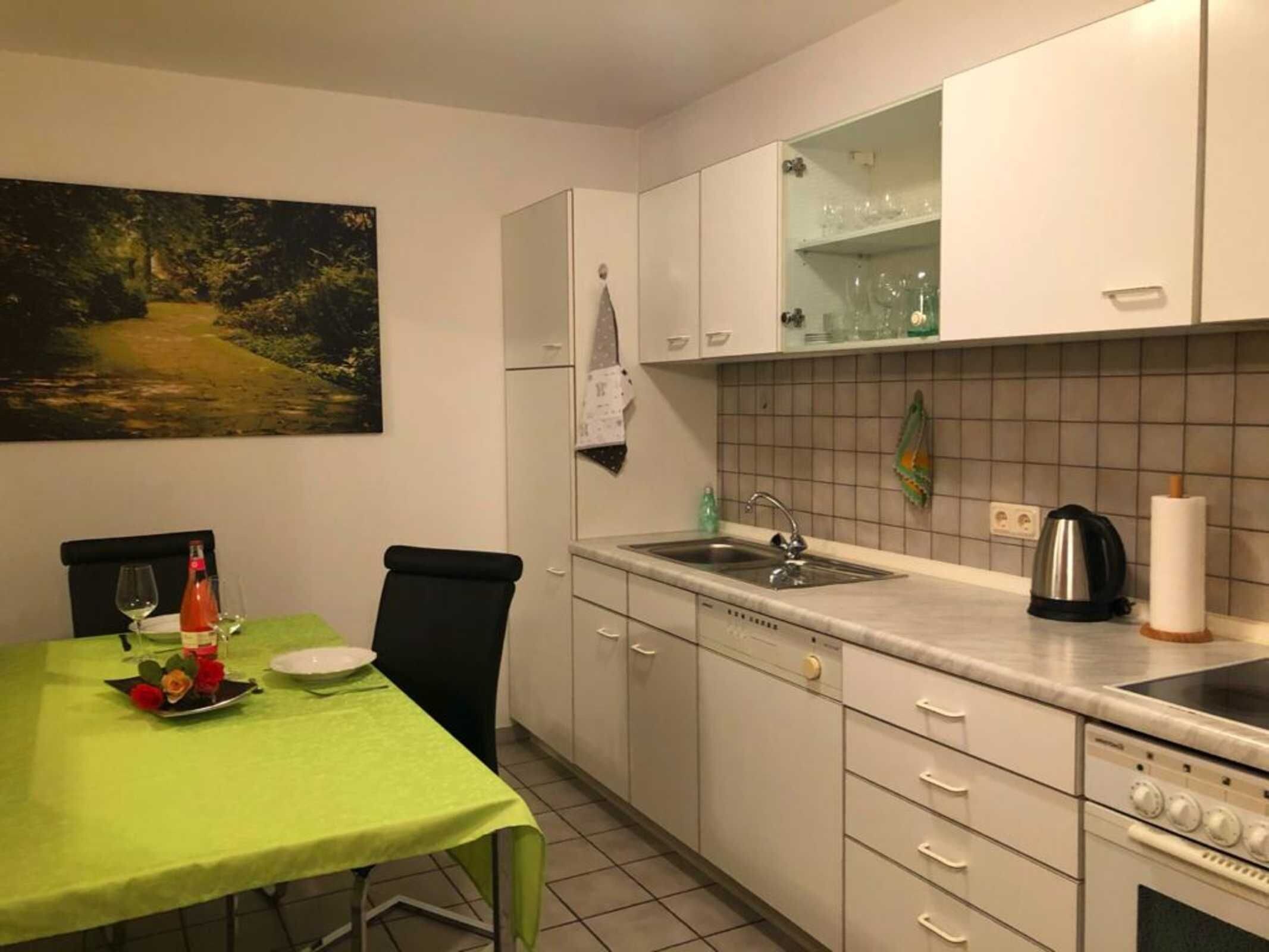 A kitchen with a dining table, chairs, a sink, and a stove.