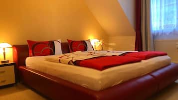 Una camera d'albergo con un letto grande, un comodino, una lampada e una finestra con tende.