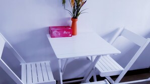A small white table with a potted plant and a pink box. - SERVICED APARTMENT FOR RENT IN PHU NHUAN DISTRICT (Ho Chi Minh)