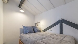 A bedroom with a bed, a wooden dresser, a desk, and a lamp. - Modern and comfortable loft equipped with every comfort. Ideal for hosting 2 people, in approximately 55 m2 of space, it is located on the third floor of an elegant period building without a lift.It is located a few minutes walk from Piazza Navona, Panth (Roma)