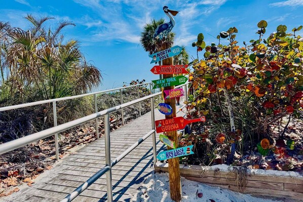 A wooden signpost with directional arrows pointing to various destinations such as North Pole, New York City, and Lake Geneva.