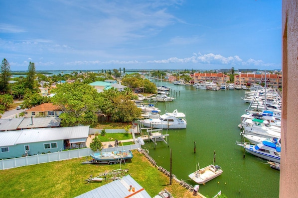 A marina with boats docked, surrounded by residential buildings and greenery.