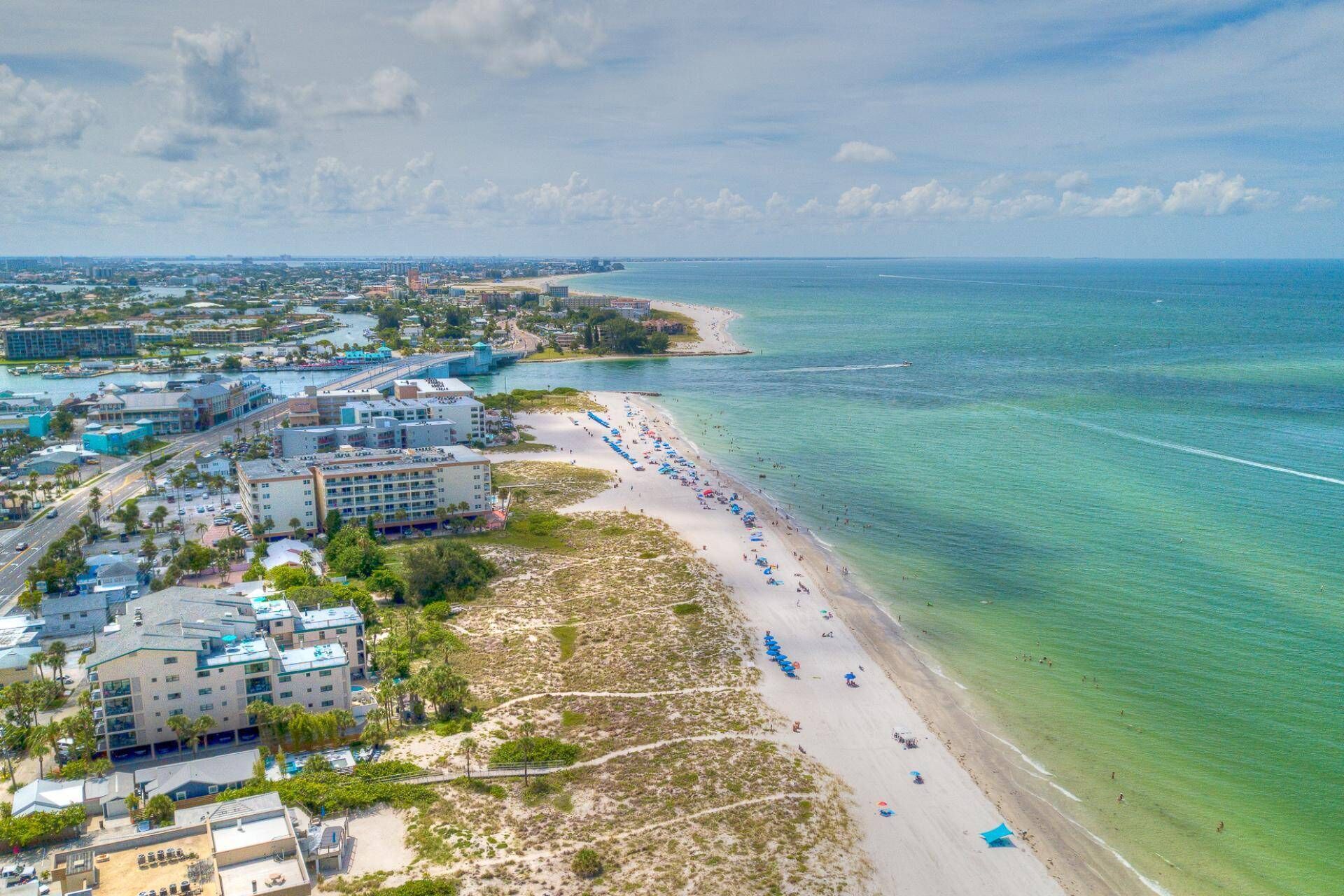 A coastal cityscape with a beach, buildings, and a clear view of the ocean.