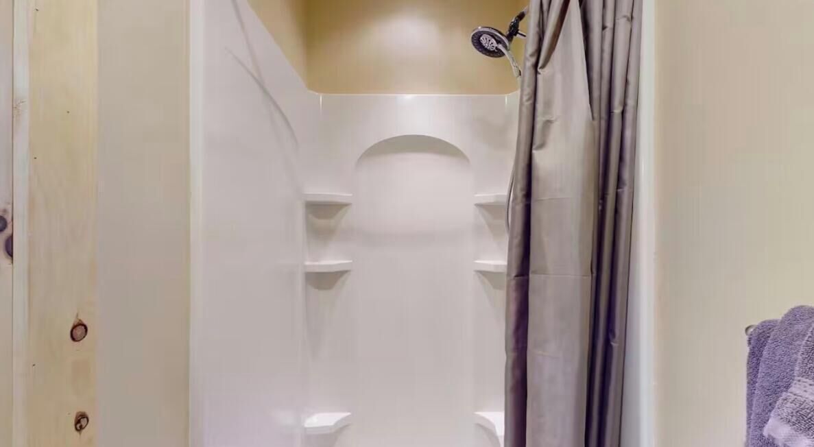 Une salle de bain avec une douche, des toilettes et un porte-serviettes.