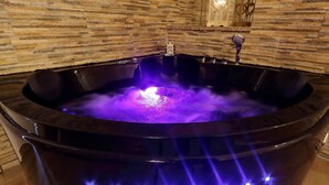 Un jacuzzi negro con fuente integrada y luces LED.