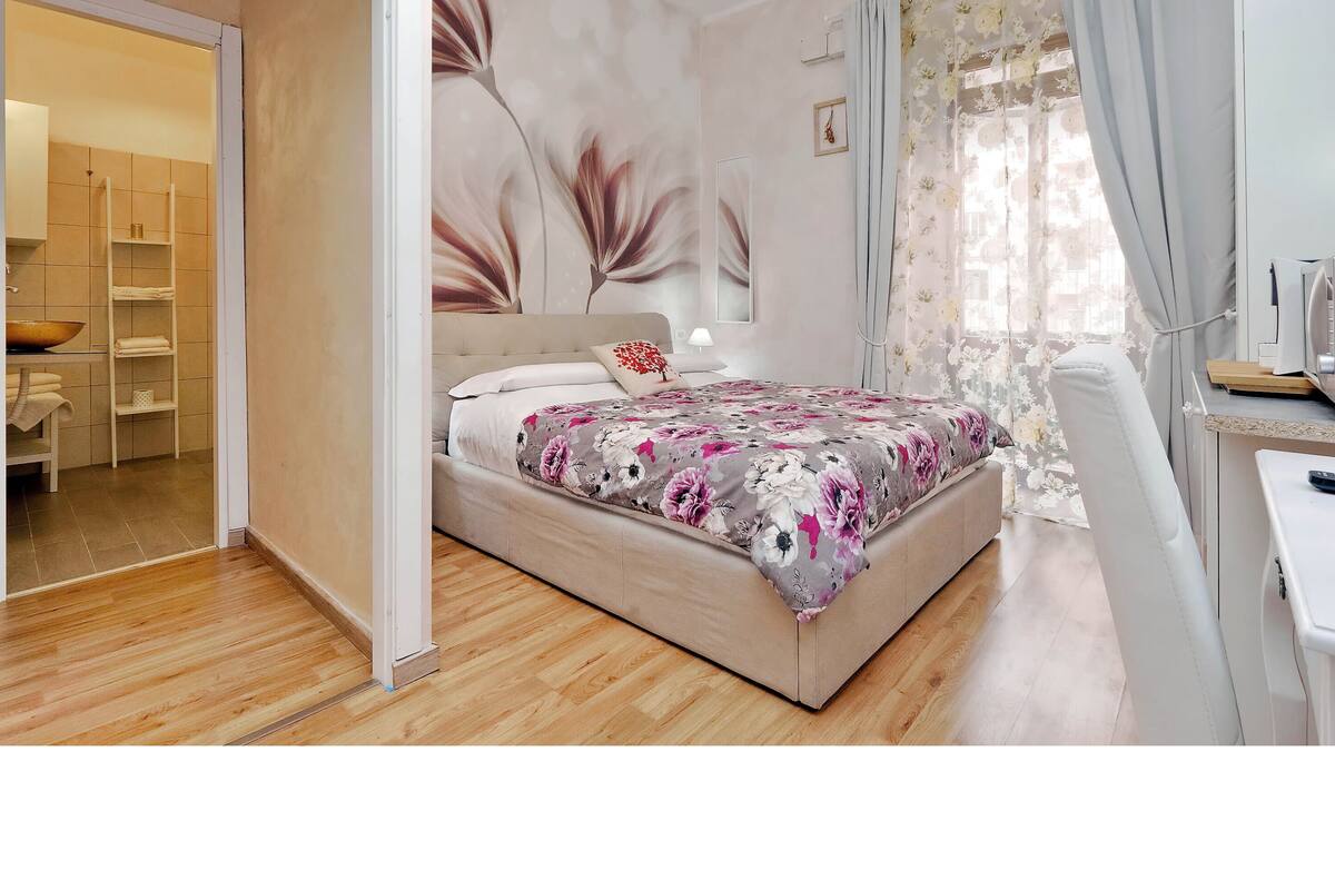 A bedroom with a bed, a desk, and a chair.