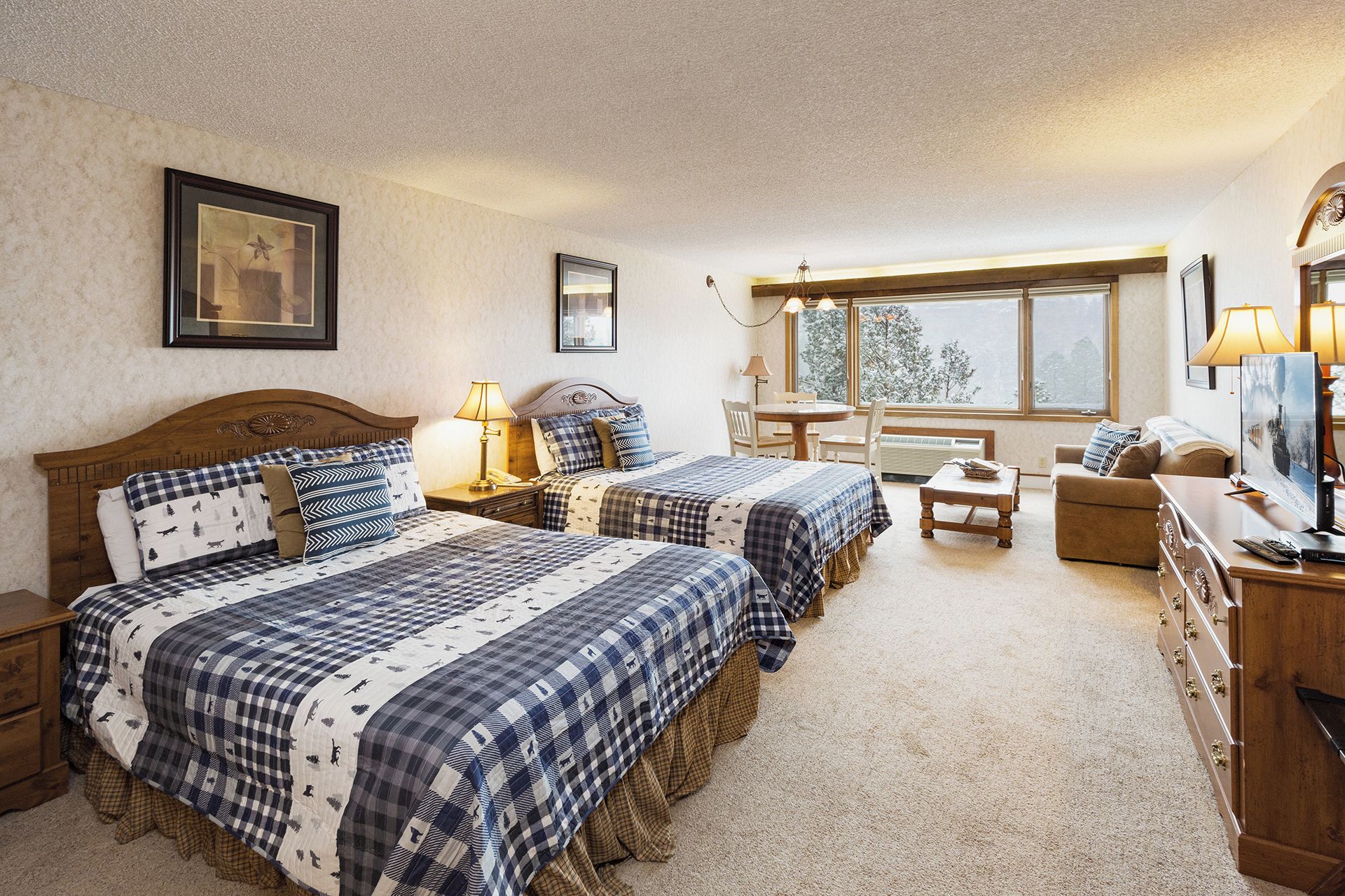 Une chambre confortable avec deux lits, une petite table et un canapé.