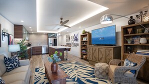 Una sala de estar moderna con un sofá, una mesa de centro, una televisión y una estantería.