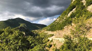 A mountainous landscape with a winding road and dense greenery.