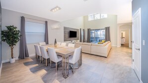 Ein modernes Wohnzimmer mit Essbereich, Kamin und Fernseher.