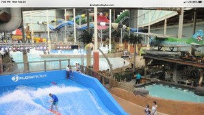 An indoor water park with a large wave pool, slides, and various water attractions.