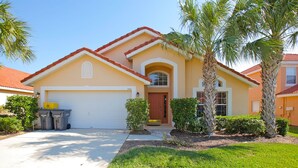 A single-story house with a garage, a front door, and a small porch. - Game Room-Gated Resort- Pool- Single Story-Close to WDW (Davenport)