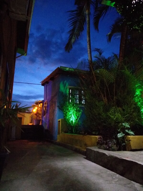 Stroll through the tranquil surroundings of this serene home, featuring a spacious balcony and lush palm trees.