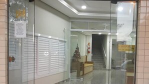 The entrance to Lebanon Praia Hotel with a clear glass door, a doormat with the hotel's name, and a staircase leading inside. - Lebanon Praia Hotel (Tramandai)