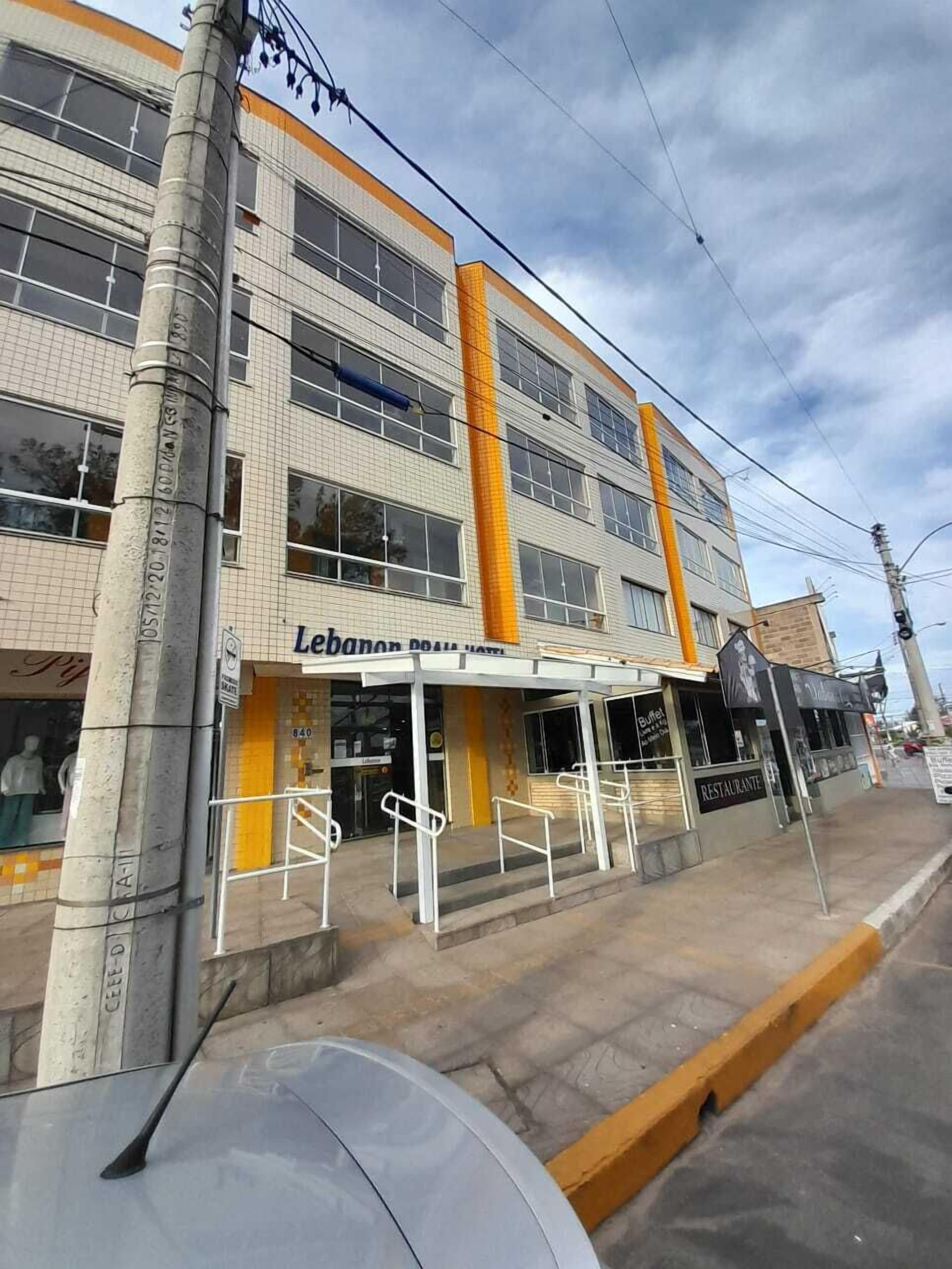 A hotel with a modern facade, large windows, and a prominent entrance with a yellow awning.