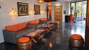Um lobby moderno com sofá, mesas e iluminação decorativa.