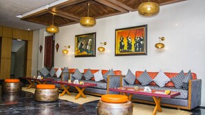 Um interior moderno com um conjunto de sofás, mesas e iluminação decorativa.