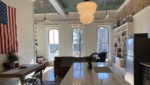 Una cocina moderna con una isla central, ventanas amplias y un ventilador de techo.