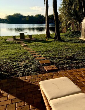 Relax by the serene lake with a scenic view, a bench, and a table for a peaceful retreat.