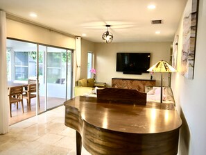 Relax in this stylish living room with a flat-screen TV, comfortable seating, and a sliding door to the outdoor patio.
