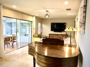 Relax in this stylish living room with a flat-screen TV, comfortable seating, and a sliding door to the outdoor patio.