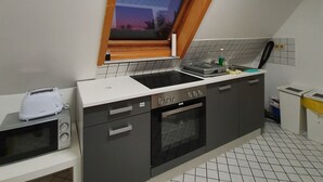 Une cuisine équipée d’un four encastré, d’un grille-pain et d’une fenêtre donnant sur le ciel.