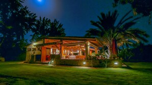 A house with a covered patio, a stone wall, and a lawn. - Casa Rustico, large pool, 350m from the beach, by the river. (Chia)