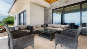 Un espacio exterior moderno para relajarse, con un conjunto de sofá, dos sillones y una mesa de centro.