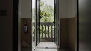 An open door leading to a balcony with a fire extinguisher on the wall. - R&B La Villa (Bologna)