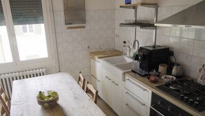 A kitchen with a white countertop, a stove, a sink, and a window. - R&B La Villa (Bologna)