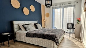 A bedroom with a bed, bedside tables, a chair, and a window with curtains. - NEAR PINARELLO BEACH - LUXURY VILLA FOR 9 PEOPLE - AIR-CONDITIONED WITH SWIMMING POOL (Sainte-Lucie de Porto-Vecchio)