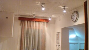 A hotel room with a ceiling fan, a clock, and a window with curtains. - 4stars FRENCH EMBASSY One Bedroom Apartment, AMZEI historic downtown, very quiet (Bucharest)