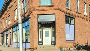 A brick building with large windows and a door labeled "Kalev East." - 3BR on SXS Snowmobile Trail w/Full Bar, Walk to Dining &Bars, Near MTU &Houghton (South Range)