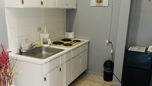 A compact kitchen with white cabinets, a stainless steel sink, a coffee maker, and a toaster. - Apartment in Rincon (Rincon)