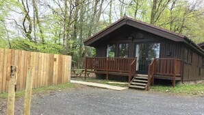 A wooden cabin with a porch and a small staircase leading to the entrance.